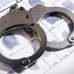 Handcuffs laying on top of fingerprint chart in file