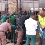 Caption; Law enforcement members searching learners alongside MEC Macie